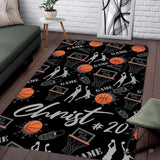 Basketball player on floor motif area rug with orange splatter graphics and athletic silhouettes on black background.