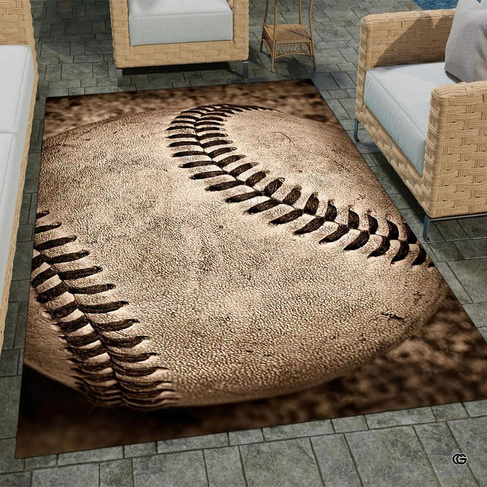 Angled patio view of a rectangular baseball area rug displayed with wicker outdoor furniture.