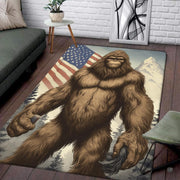 Muscular Bigfoot muscle mat area rug displaying a patriotic flag sky above alpine pine trees. - thumbnail image 1 of 5