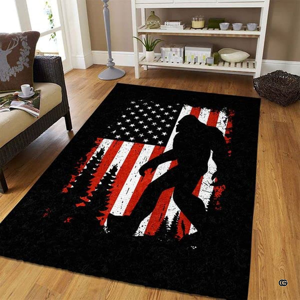 Bigfoot silhouette striding past pines over distressed red and white stripes on an American flag ruger area rug.