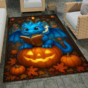 Cute blue baby dragon reading a book seated atop a glowing Halloween pumpkin surrounded by autumn leaves area rug. - thumbnail image 1 of 8