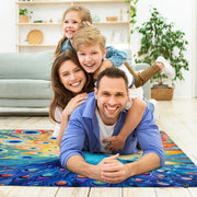 Fireside lounge setting with person relaxing near the colorful peacock area rug - thumbnail image 5 of 7