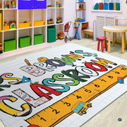 Educational theme area rug styled in bright study space with colorful wooden furniture. - thumbnail image 3 of 7