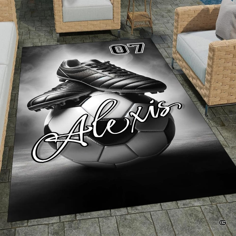 Monochrome black soccer cleats resting on soccer ball rectangular area rug.