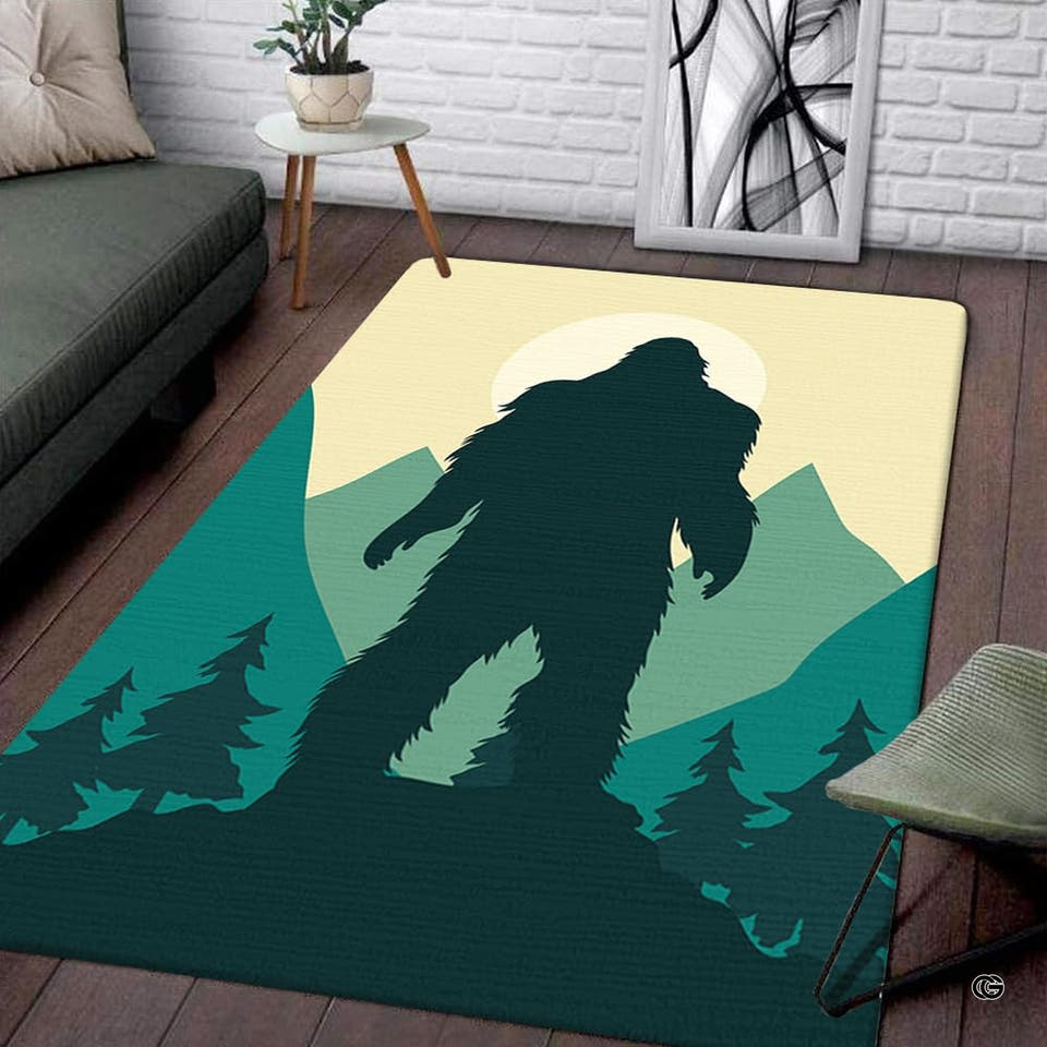 Living room setup with hardwood floor and white brick wall showcasing bigfoot silhouette mountain area rug