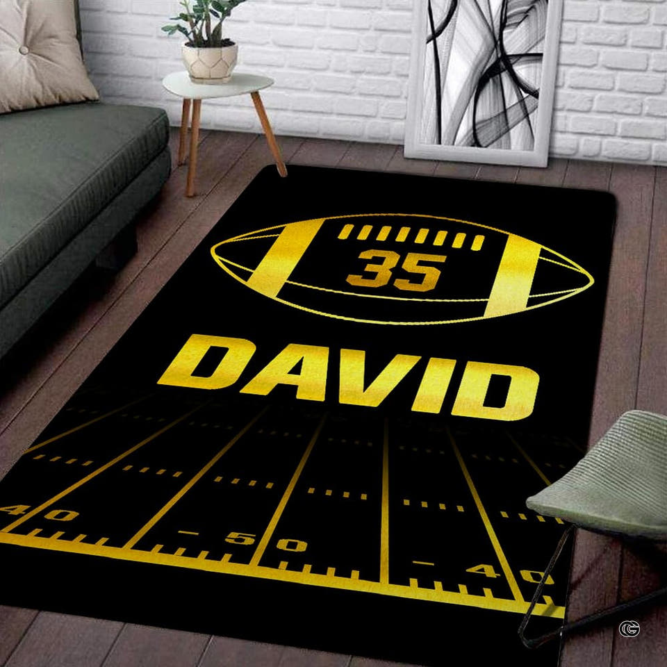 Gold football gridiron field rectangular area rug with yard lines displayed on living room wood flooring.