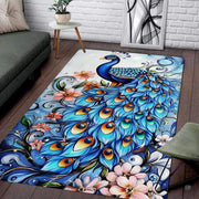 Majestic peacock area rug featuring turquoise plumage, golden eye-spots, and peach blossoms on pale blue background. - thumbnail image 1 of 8