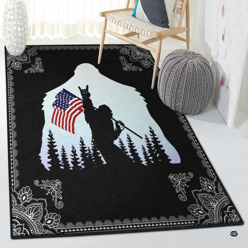 Bigfoot rock on American flag area rug displayed flat showing forest silhouette and white mandala border details.