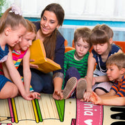 Lifestyle scene featuring teacher and students around book reading rug. - thumbnail image 5 of 7