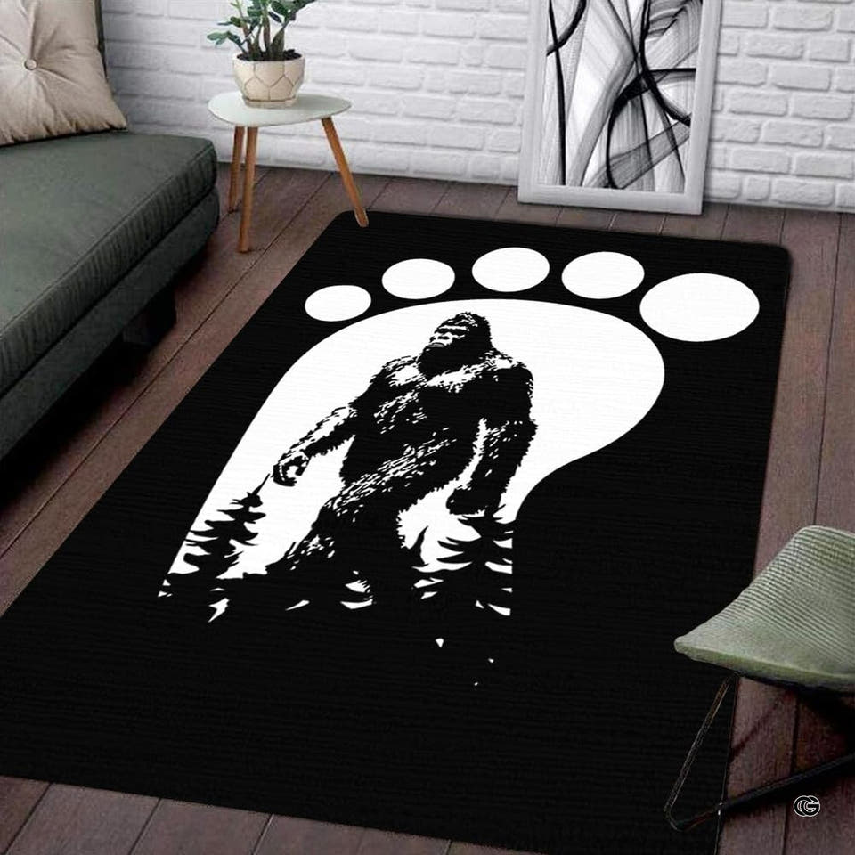 Living room setup with hardwood floor and white brick wall showcasing bigfoot footprint track area rug