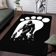 Living room setup with hardwood floor and white brick wall showcasing bigfoot footprint track area rug - thumbnail image 1 of 5