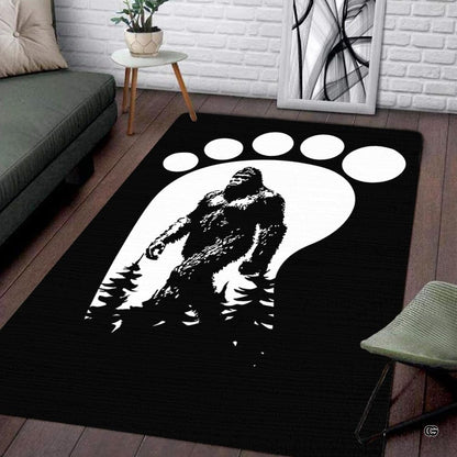 Living room setup with hardwood floor and white brick wall showcasing bigfoot footprint track area rug - thumbnail image 1 of 5