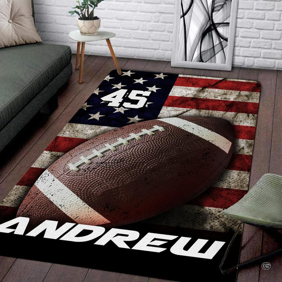 Patriotic American flag football rectangular area rug displayed on wood flooring in a modern living room.
