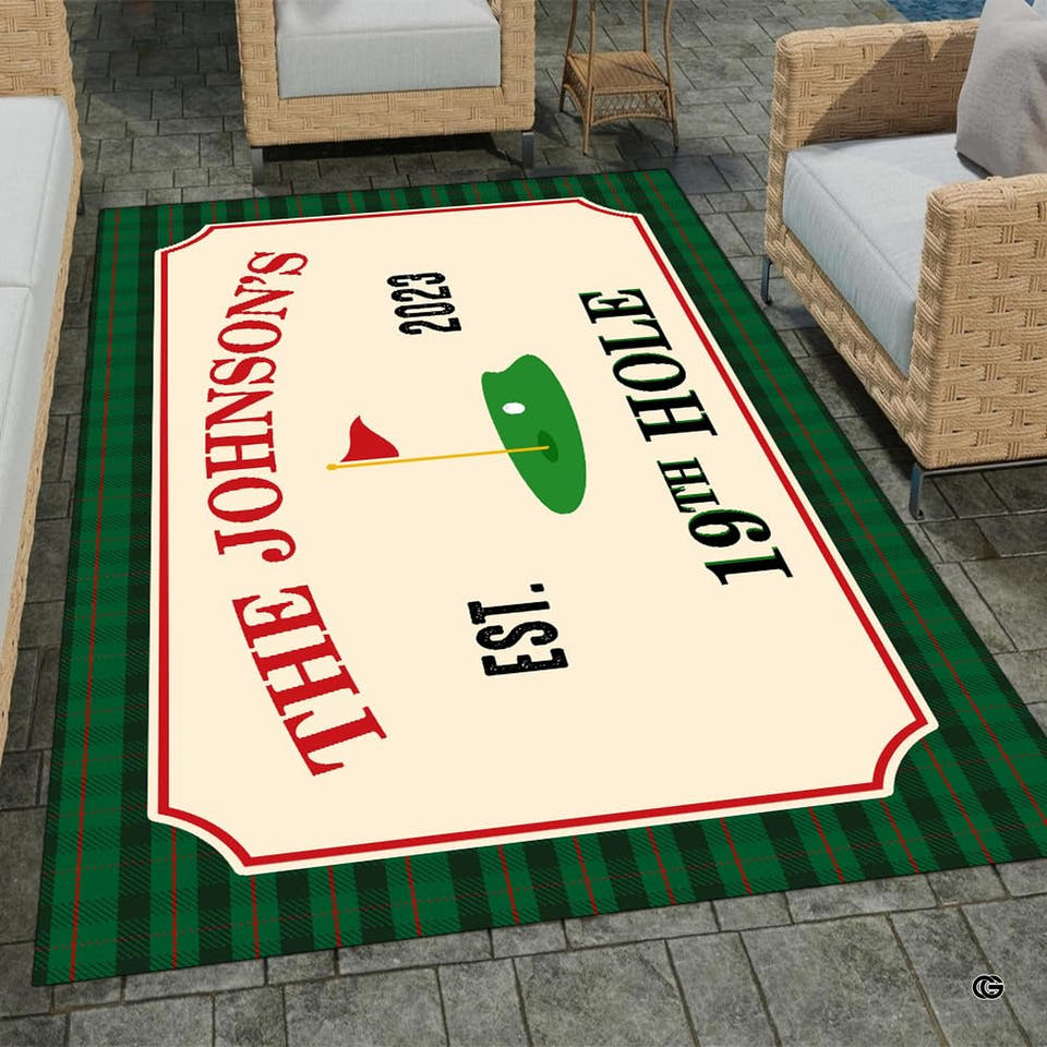Patio setting featuring wicker armchairs framing the rectangular golf tartan plaid area rug on stone pavers.