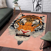 Blush pink stylized tiger face living room area rug in front of a modern couch - thumbnail image 1 of 8