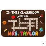 Classroom teacher area rug featuring dark wood plank texture, crossword tiles, and school illustrations.