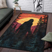 Top-down floor view of Bigfoot area rug showing Sasquatch walking past pine trees during a vibrant yellow sunset. - thumbnail image 1 of 5