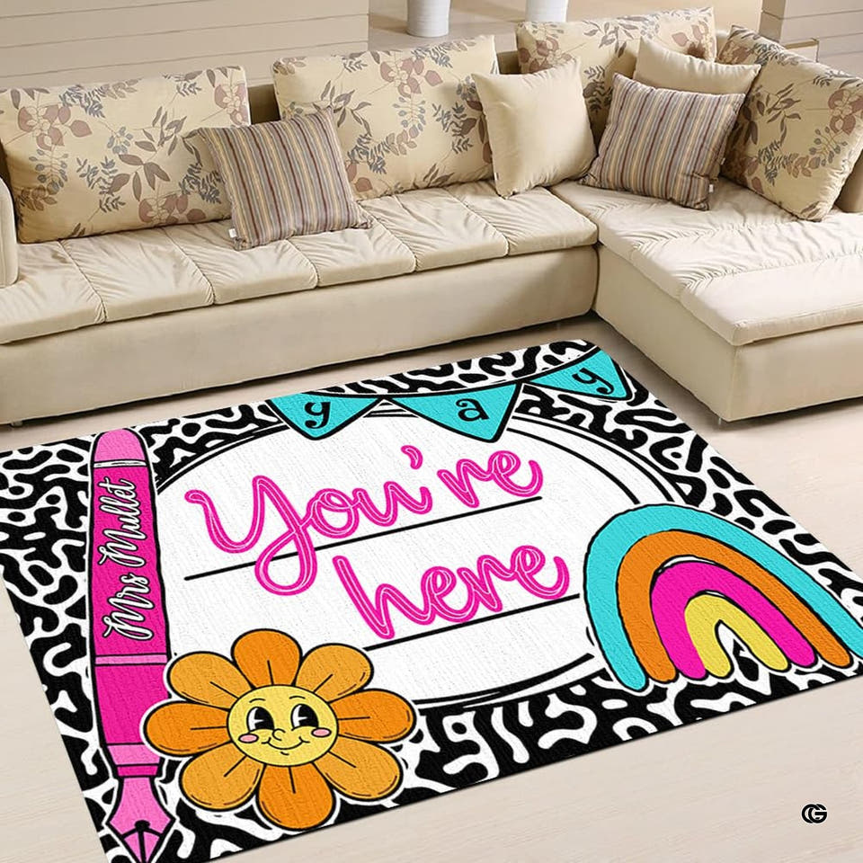 Classroom area rug with smiling daisy blossom, rainbow arches, and pennant flags for elementary learning spaces.