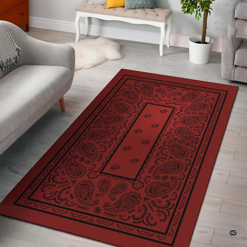 Crimson western paisley bandana area rug showing intricate teardrop swirls and border artwork in a bright room.