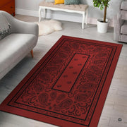 Crimson western paisley bandana area rug showing intricate teardrop swirls and border artwork in a bright room. - thumbnail image 1 of 9
