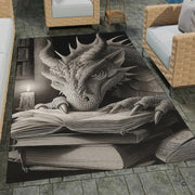 Charcoal fantasy dragon resting its head and claws on an open spellbook beside a candle in an ancient library area rug. - thumbnail image 1 of 8