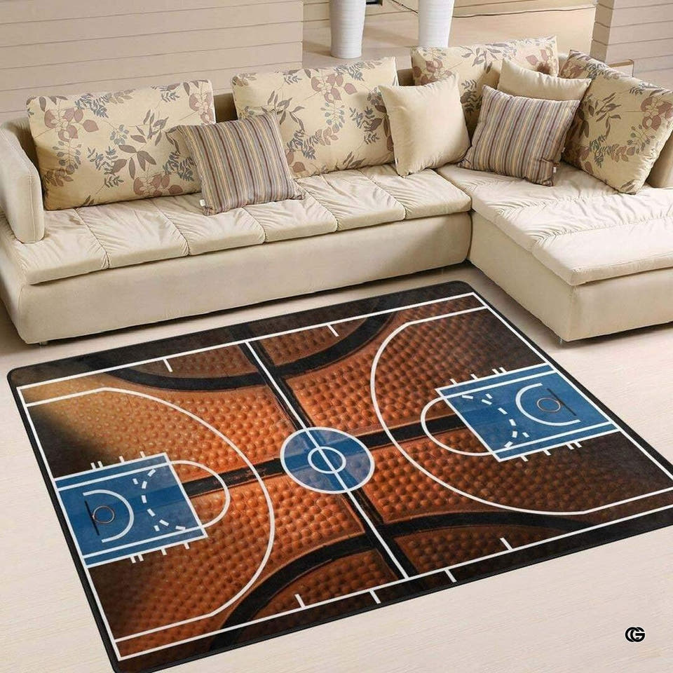 Basketball court rectangular area rug with pebbled ball texture displayed in front of a sectional sofa.