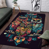 Four colorful boho owls with mandala pattern feathers perched together on a dark area rug
