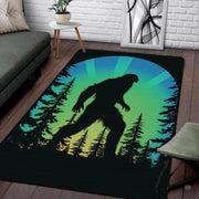 Retro Bigfoot silhouette home area rug displaying a Sasquatch walking through pines before a colorful sunburst. - thumbnail image 1 of 5