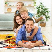 Lifestyle living room scene featuring family lounging on flaming basketball area rug. - thumbnail image 5 of 7