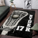 Lacrosse stick head holding a ball graphic artwork on black athletic area rug.