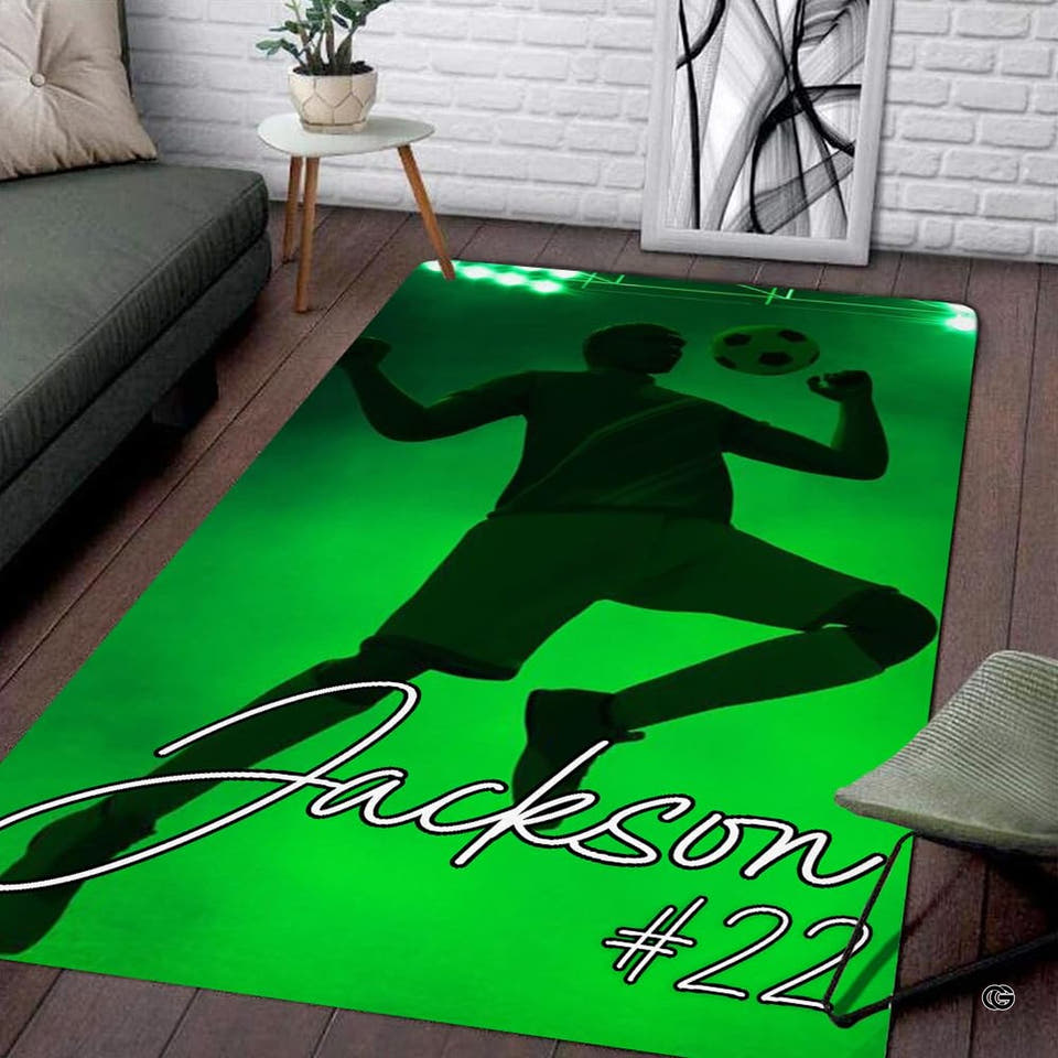 Soccer player mid-air volley sports room area rug displayed on dark wood planks.