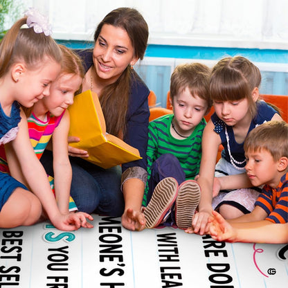 Lifestyle scene featuring teacher and students gathered around golden rule rug. - thumbnail image 5 of 7