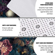 Closeup detail of printed painterly petals, golden butterflies, and skull contours on the area rug - thumbnail image 6 of 8