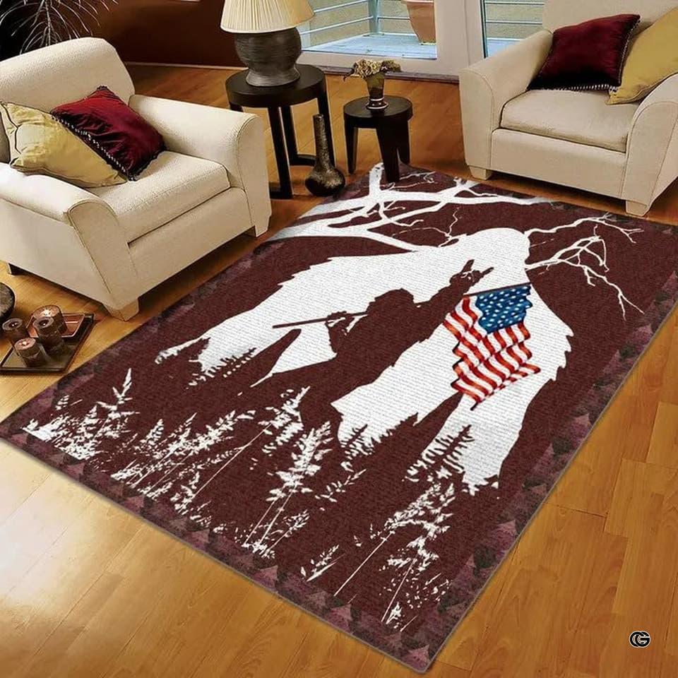 Bigfoot American flag pine forest area rug displayed across hardwood flooring in a rustic living room.