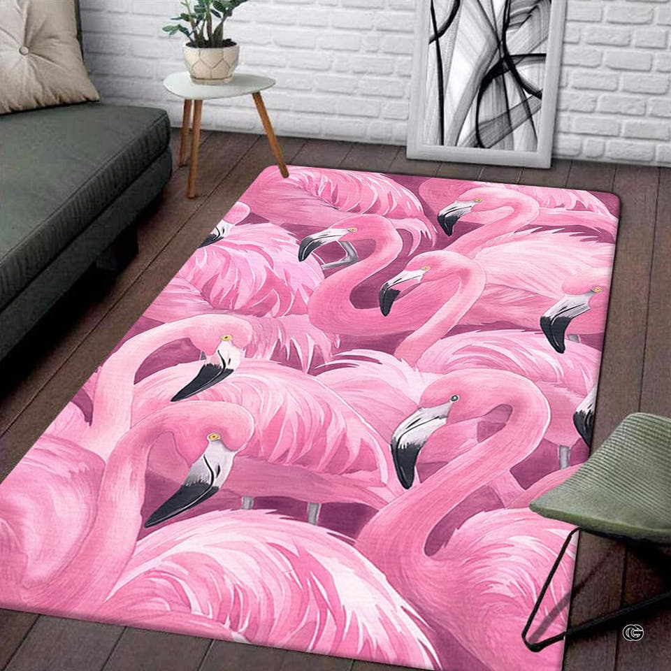 Living room display of a rectangular flock of pink flamingos area rug on wood flooring.