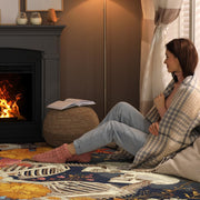 Fireside living room scene with a person sitting on the floral skeleton area rug - thumbnail image 6 of 8